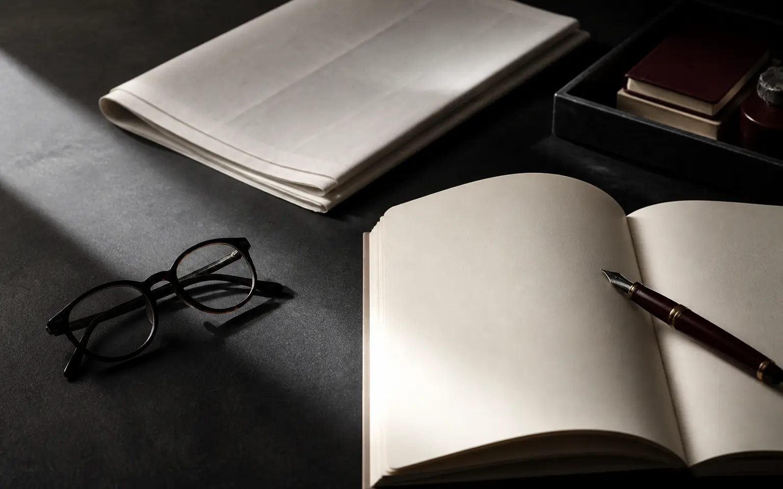 Open journal, fountain pen, and reading glasses on an editorial desk